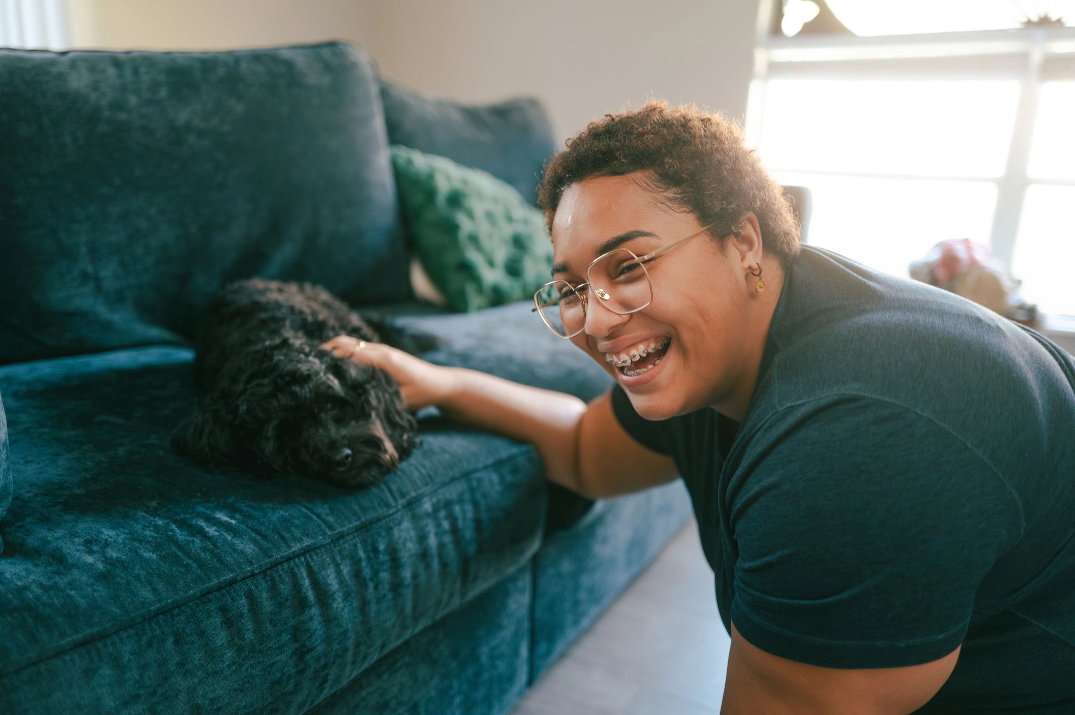 Woman cuddling a puppy on a couch in a home-like setting